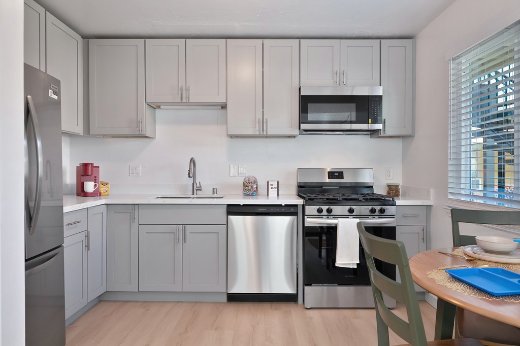A kitchen with a stainless steel refrigerator, oven, and microwave.