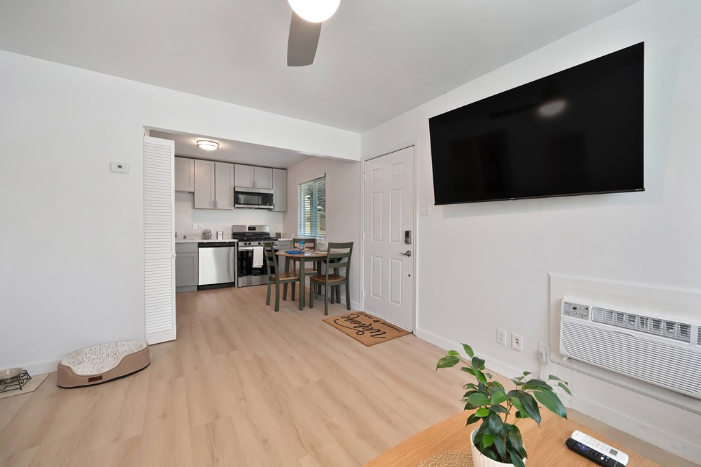 A living room with a flat screen TV mounted on the wall.