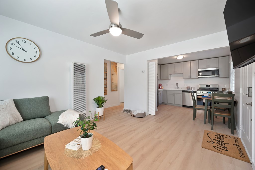 A living room with a green couch and a wooden coffee table.