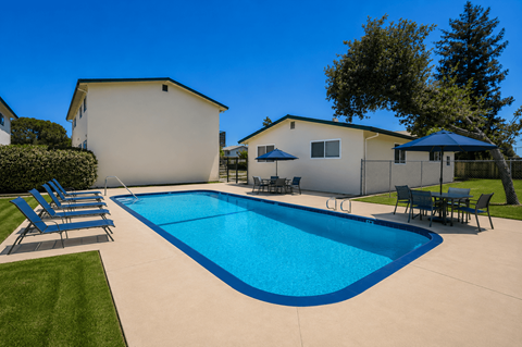 A swimming pool in a backyard with a house in the background.