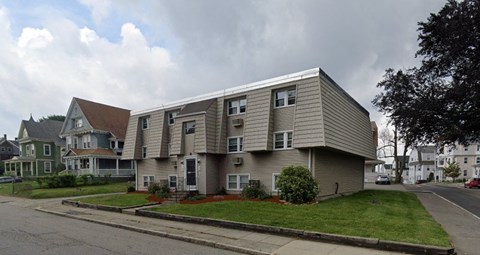 a apartment building with a roof on the side of a street