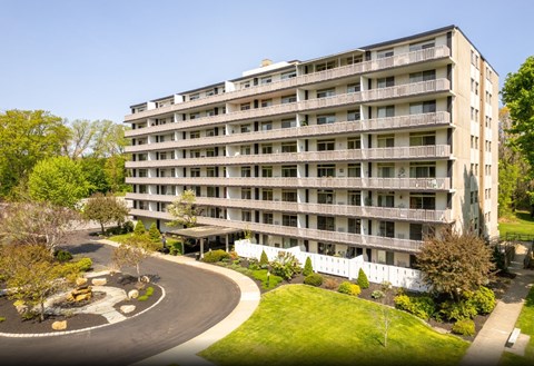 A large apartment building with a curved driveway in front.