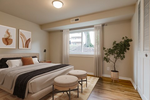 A bedroom with a large bed and a small tree.