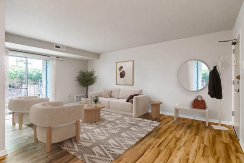 A living room with a white couch and a rug.