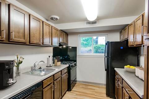 A kitchen with wooden cabinets and black appliances.