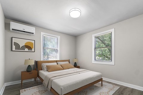 A bedroom with a bed, nightstands, and a window.