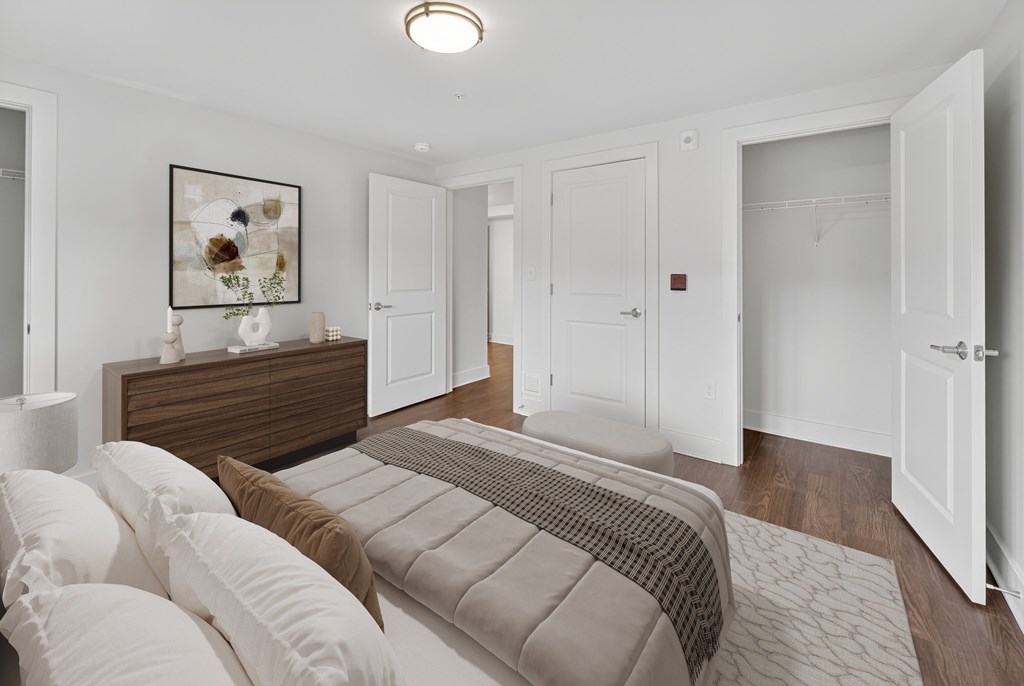A bedroom with a bed, dresser, and a painting on the wall.