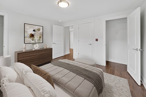 A bedroom with a bed, dresser, and a painting on the wall.