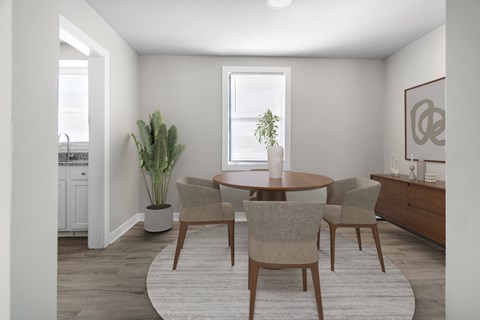 A dining room with a round table and chairs.