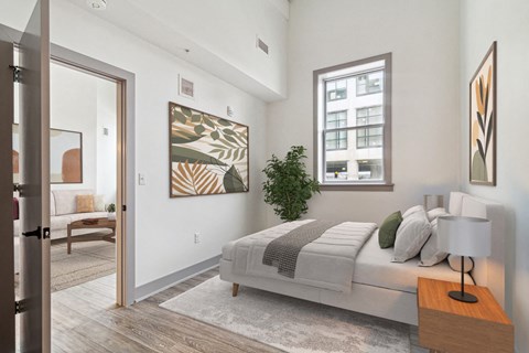 a bedroom with a bed and a door to a living room