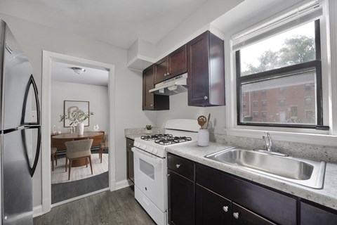 A kitchen with a stove top oven and a refrigerator.