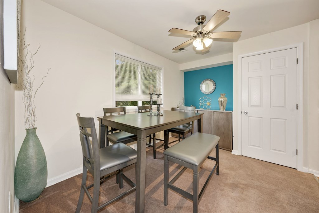 A dining room with a table and chairs.