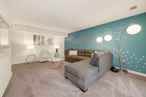 A living room with a grey sofa and a white coffee table.