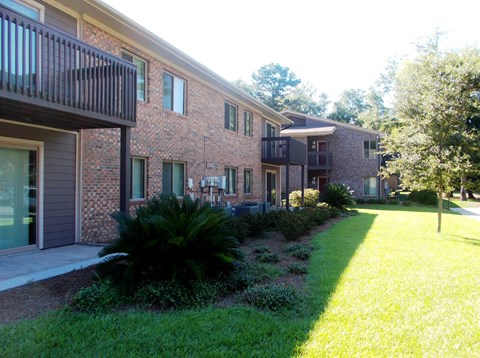 A brick building with a green lawn in front.