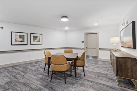 A conference room with a table, chairs, and pictures on the wall.