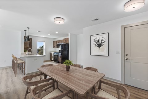A modern dining room with a wooden table and chairs.