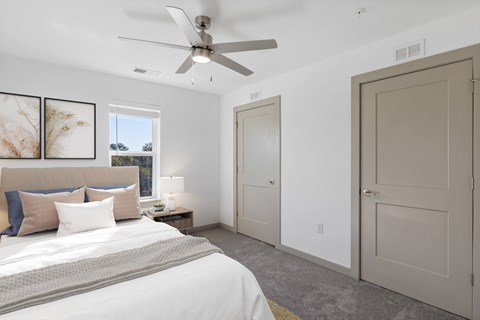 A bedroom with a large bed and a ceiling fan.