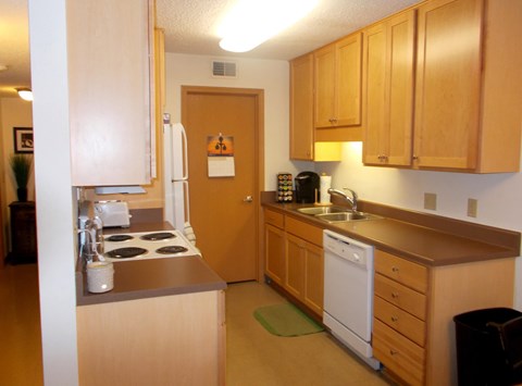 A kitchen with wooden cabinets and a white dishwasher.