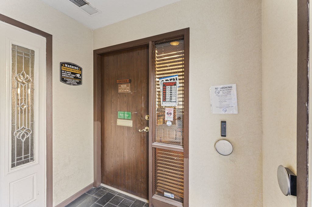 A hallway with a door and a sign on the wall.