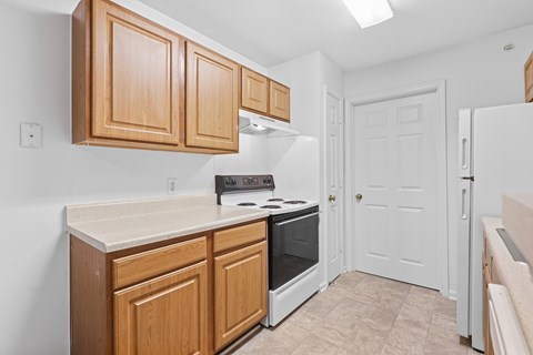 A kitchen with wooden cabinets and a white refrigerator.