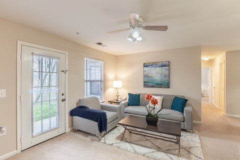 A living room with a grey couch, a coffee table, and a painting on the wall.