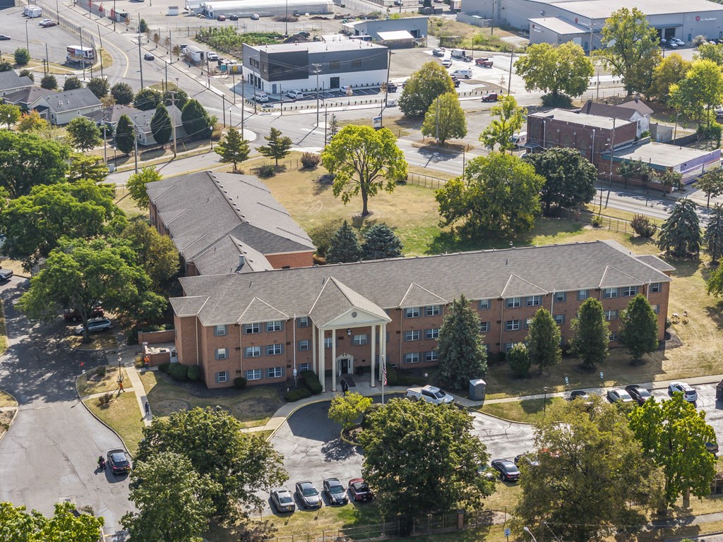 A large apartment complex with a parking lot in front.
