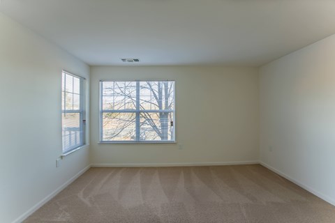 A room with a carpeted floor and a window.