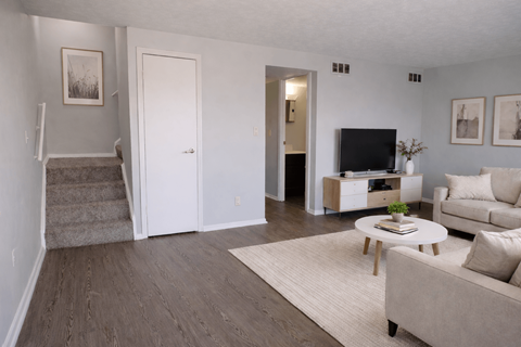 A living room with a couch, coffee table, and television.
