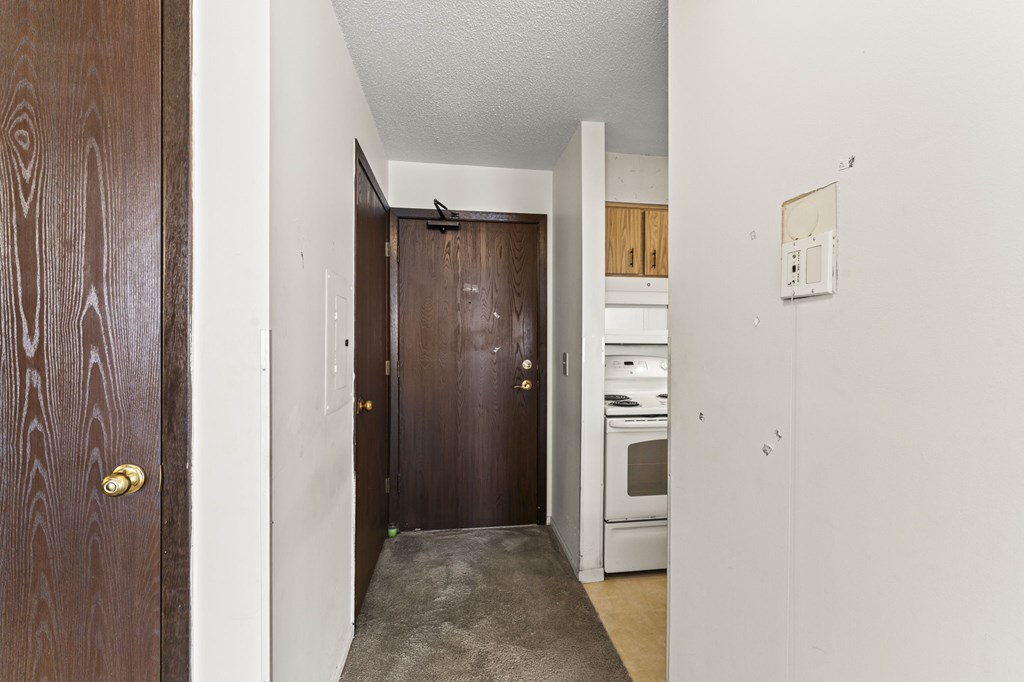 A hallway with a brown door and a white door.