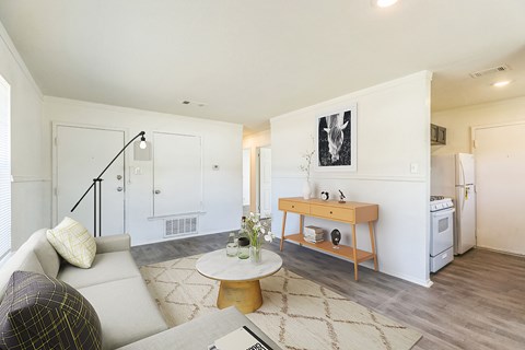 A living room with a couch, a coffee table, and a painting on the wall.