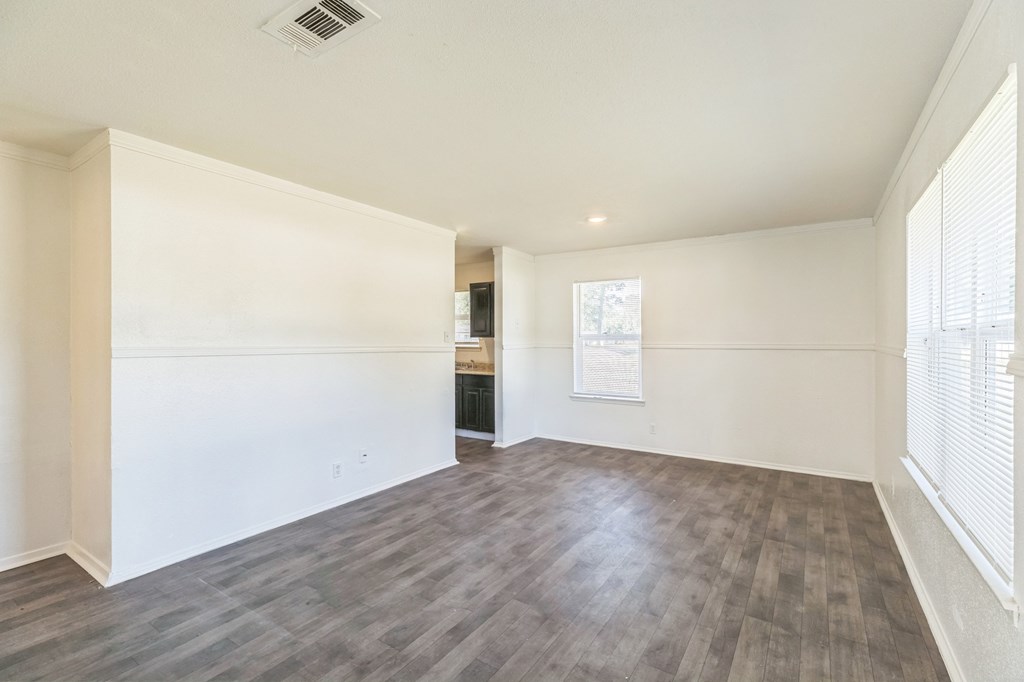 A room with wooden flooring and white walls.