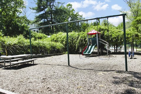 A playground with a swing set and a slide.