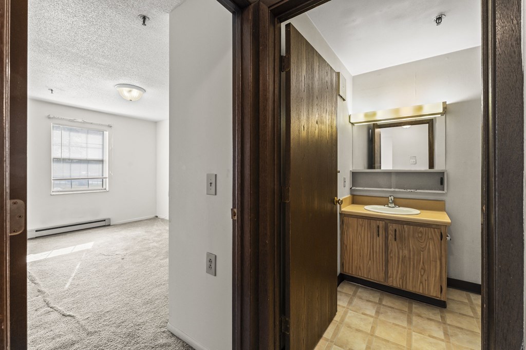 A bathroom with a sink and mirror is shown.