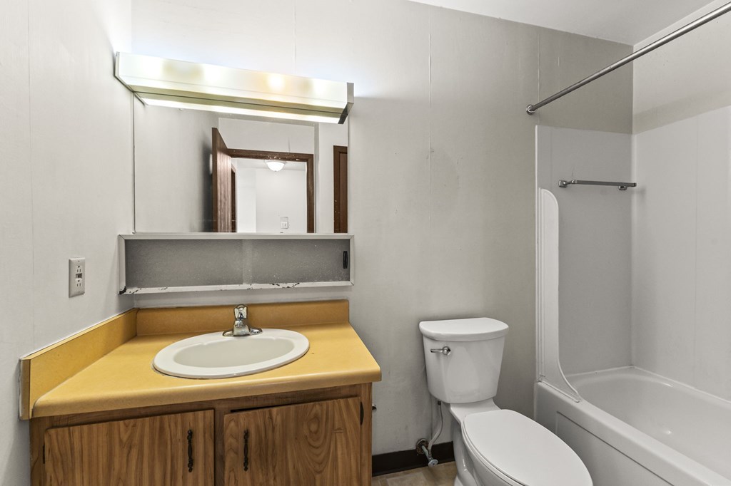 A bathroom with a sink, toilet, and bathtub.