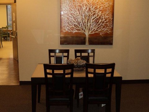 A brown table with two chairs and a vase on it.