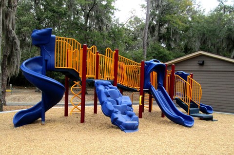 A playground with blue and yellow slides.