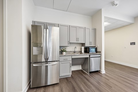 A kitchen with a refrigerator, microwave, and dishwasher.