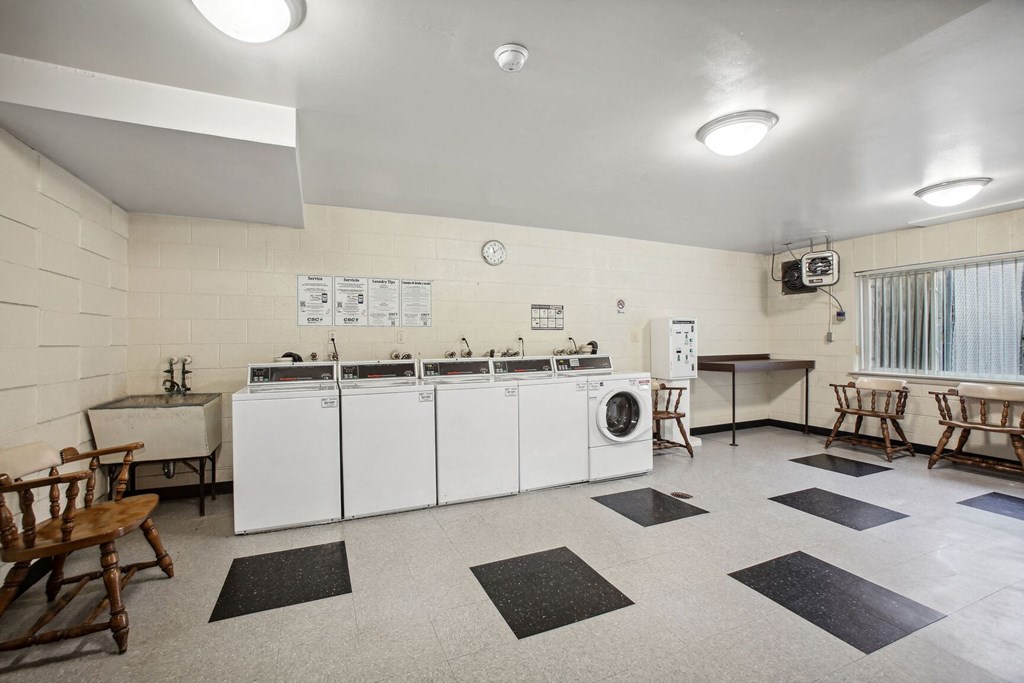 a laundry room with washer and dryers and tables and chairs