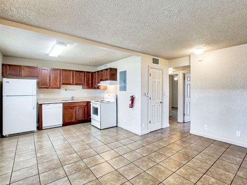 A kitchen with white appliances and brown cabinets.