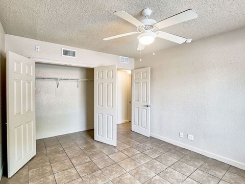 A room with a ceiling fan and tiled flooring.