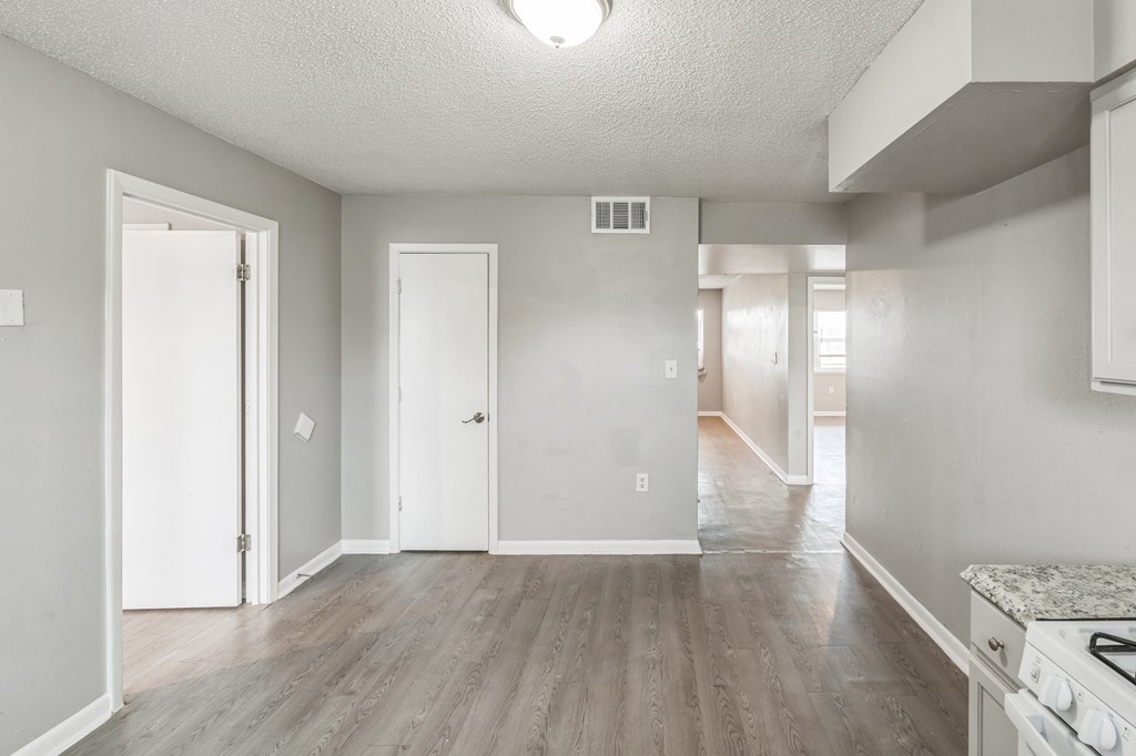 A spacious room with a stove on the right side.