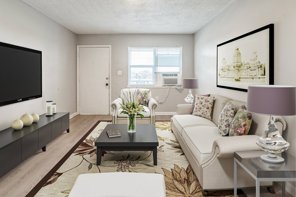 A living room with a white couch, a black coffee table, and a painting on the wall.