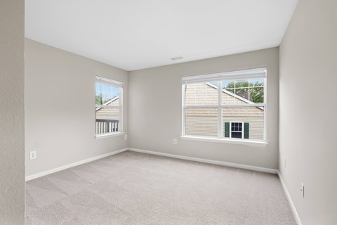 A spacious room with large, bright windows.