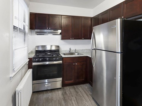 A kitchen with a stainless steel refrigerator, oven, and sink.