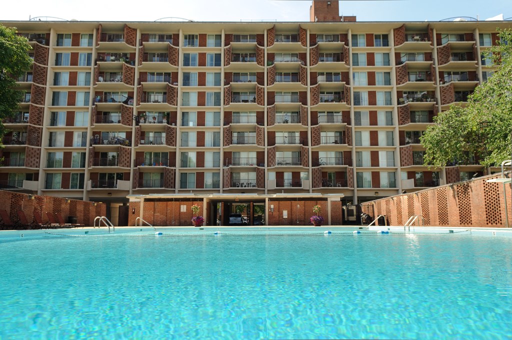 A large building with a pool in front of it.