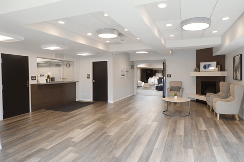 A spacious office with wood flooring and white walls.