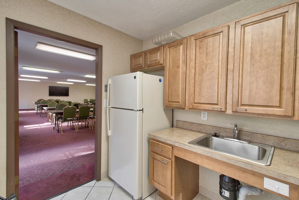 A kitchen with a white refrigerator and wooden cabinets.