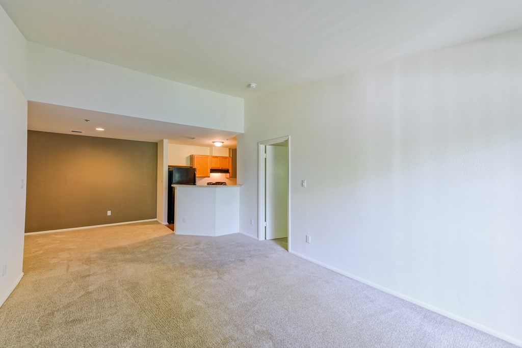 the living room and kitchen of an empty apartment