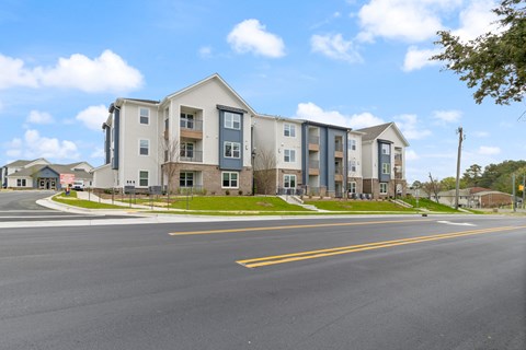 Apartment building on a street corner with a clear blue sky.
