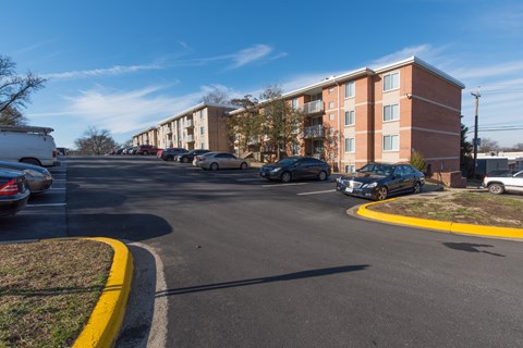 A parking lot with cars and apartment buildings in the background.